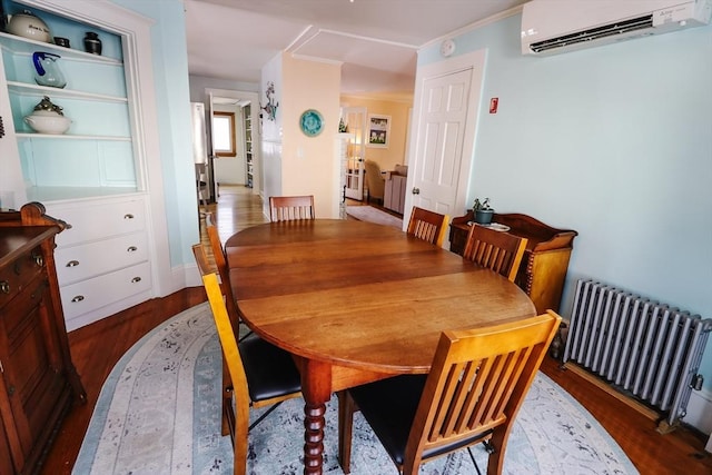 dining area with radiator heating unit, dark hardwood / wood-style floors, and an AC wall unit