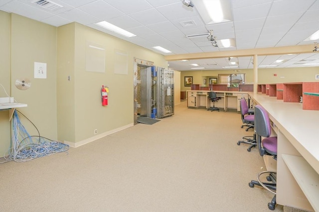 office featuring a drop ceiling, carpet floors, and built in desk