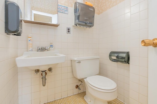 bathroom with tile patterned floors, toilet, and tile walls