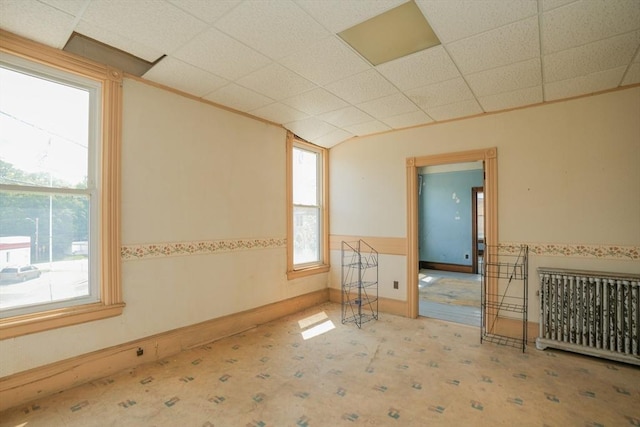 empty room with a drop ceiling and light colored carpet