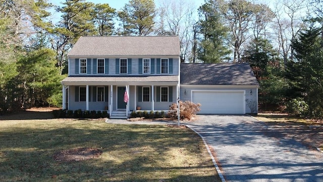 colonial inspired home with a garage, covered porch, driveway, and a front yard