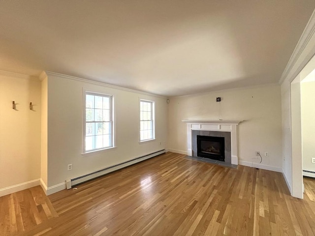 unfurnished living room with light wood-type flooring, a fireplace, a baseboard heating unit, and crown molding