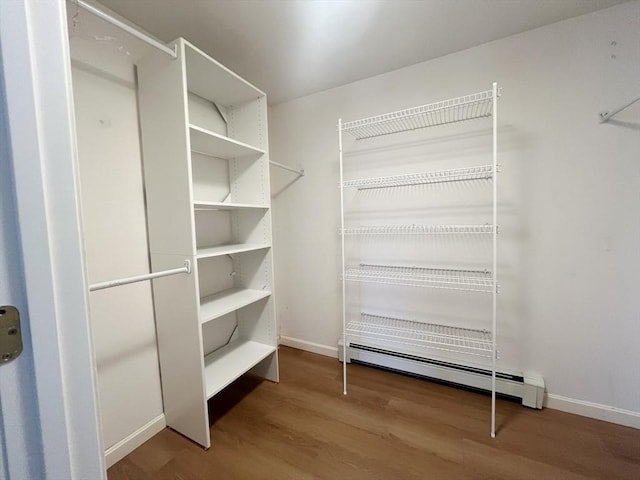 spacious closet with baseboard heating and wood finished floors