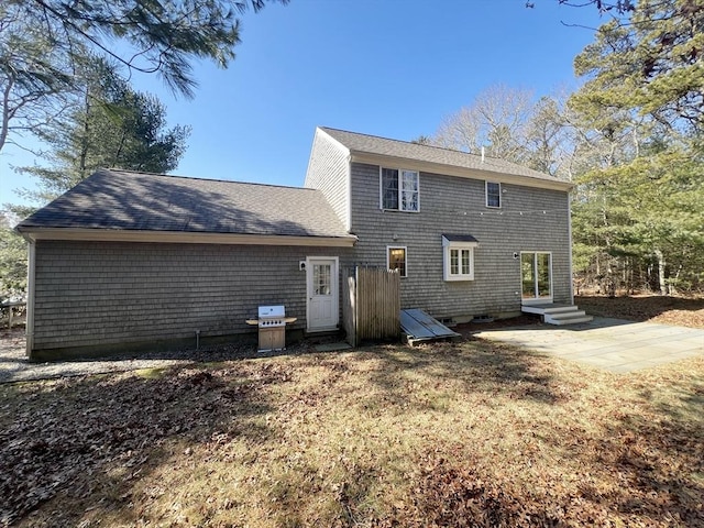 back of house with a shingled roof, entry steps, and a patio