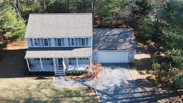 view of front facade featuring a garage, driveway, a shingled roof, and a front yard