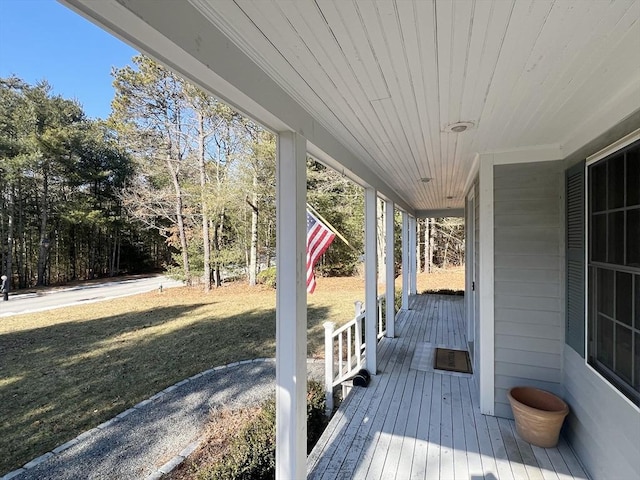 wooden terrace featuring a yard