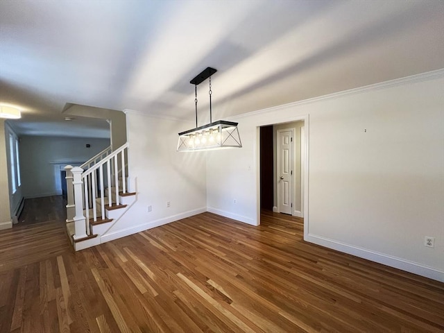 unfurnished dining area with baseboards, crown molding, stairway, and wood finished floors