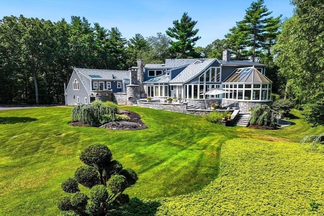 32-70 Lazell St, Hingham, MA 02043 - back of property with a chimney, a lawn, a sunroom, a garage, and stone siding
