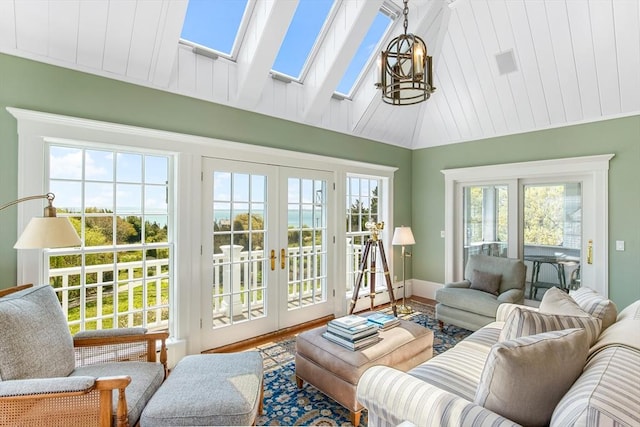 living area featuring a notable chandelier, wood finished floors, lofted ceiling with skylight, and french doors