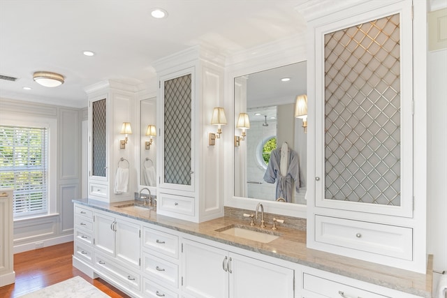 bathroom featuring dual bowl vanity, hardwood / wood-style flooring, and ornamental molding