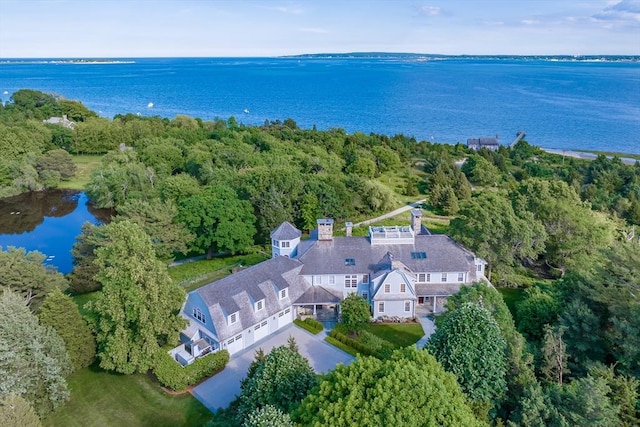 aerial view featuring a wooded view and a water view