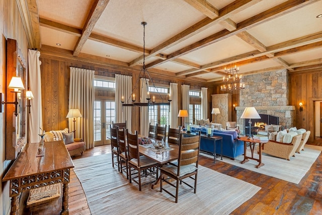 dining space with coffered ceiling, an inviting chandelier, a fireplace, beamed ceiling, and hardwood / wood-style flooring