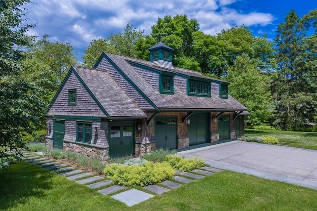 view of front of home featuring stone siding, driveway, and a front yard