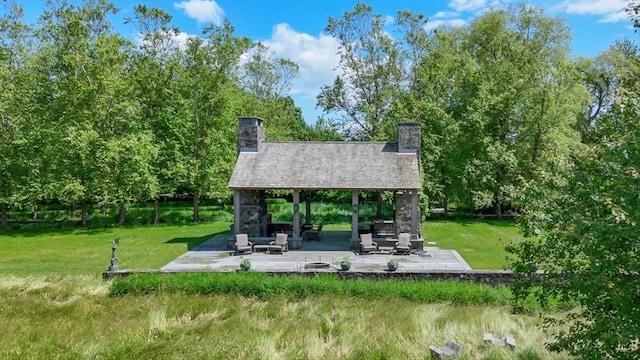 view of community featuring a lawn and a patio