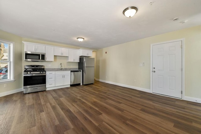 kitchen featuring white cabinetry, dark wood-style floors, appliances with stainless steel finishes, and a sink