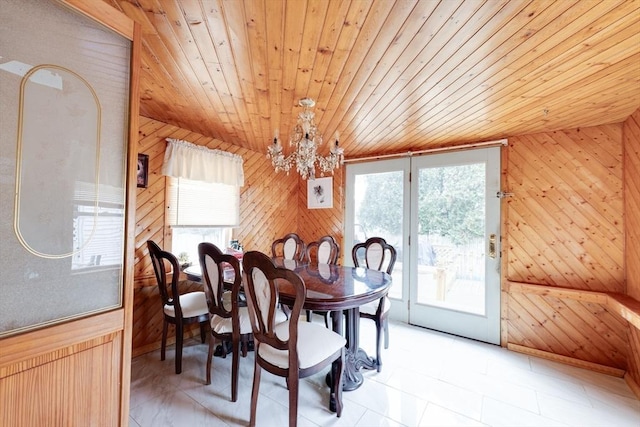 dining room featuring a wealth of natural light, wooden walls, and wooden ceiling