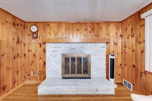 details with a brick fireplace, wood-type flooring, and wood walls