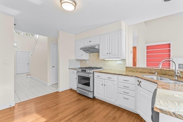 kitchen with white cabinets, sink, gas stove, and light hardwood / wood-style floors