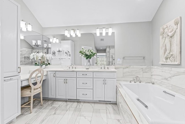 bathroom with a tub, vanity, and lofted ceiling