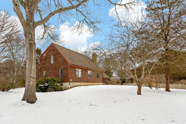 view of snowy exterior with a chimney