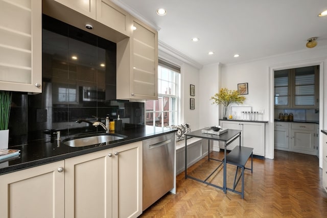 kitchen with cream cabinetry, backsplash, sink, light parquet floors, and stainless steel dishwasher