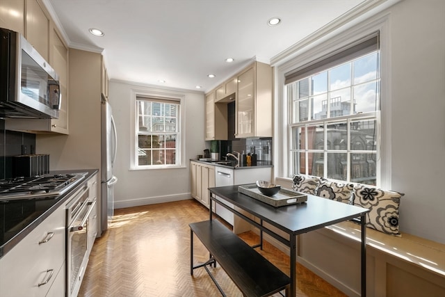 kitchen featuring a wealth of natural light, stainless steel appliances, cream cabinets, and decorative backsplash