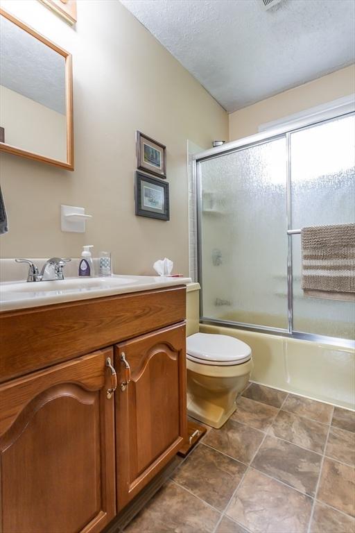 22 Bayview Ave, Berkley, MA 02779 - bathroom featuring vanity, enclosed tub / shower combo, toilet, and a textured ceiling