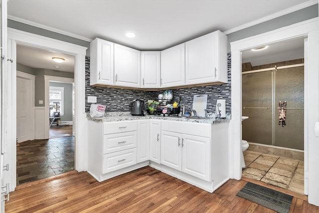 6-8 Maurice Ave, Lawrence, MA 01841 - kitchen featuring decorative backsplash, white cabinetry, light wood-style floors, ornamental molding, and light stone counters