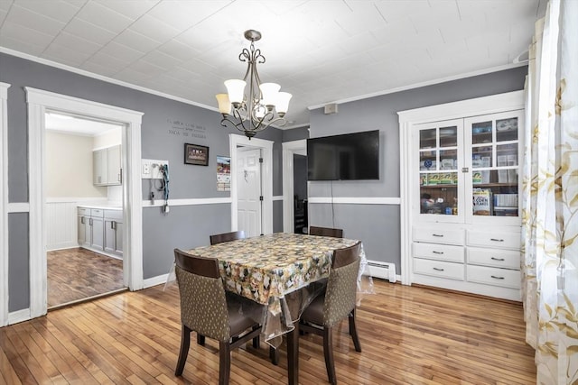6-8 Maurice Ave, Lawrence, MA 01841 - dining area featuring a chandelier, ornamental molding, light wood-style flooring, and a baseboard heating unit