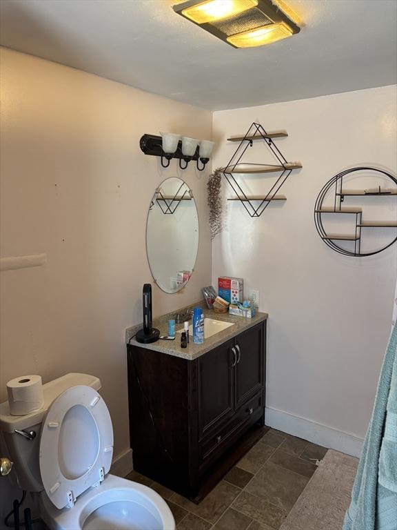 bathroom with vanity, toilet, and baseboards