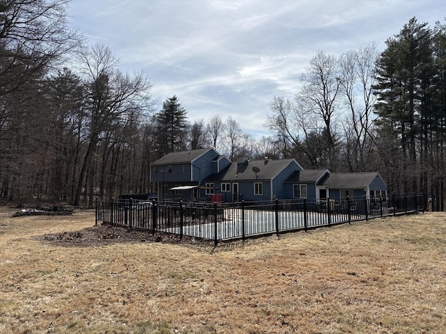 back of property featuring a yard and fence