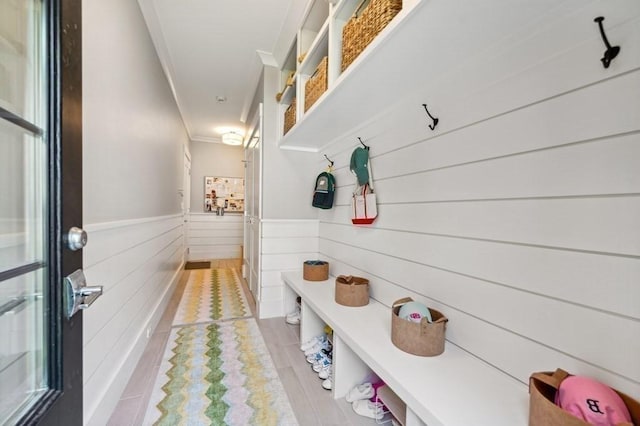 40 Carver Rd, Wellesley, MA 02481 - mudroom with crown molding, light wood-type flooring, wainscoting, and wooden walls