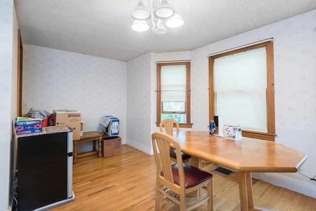 98 Safford St, Quincy, MA 02171 - dining space featuring light wood finished floors, a chandelier, wallpapered walls, and a textured ceiling
