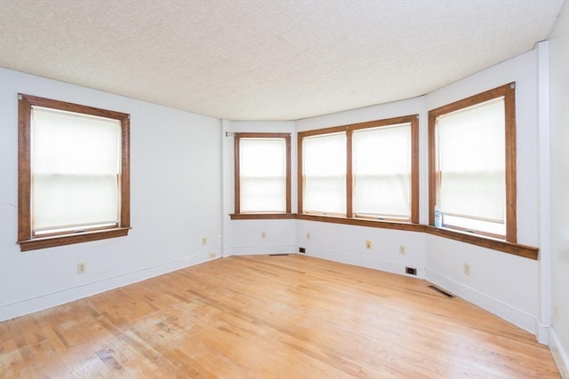 98 Safford St, Quincy, MA 02171 - spare room featuring wood finished floors, a textured ceiling, and healthy amount of natural light