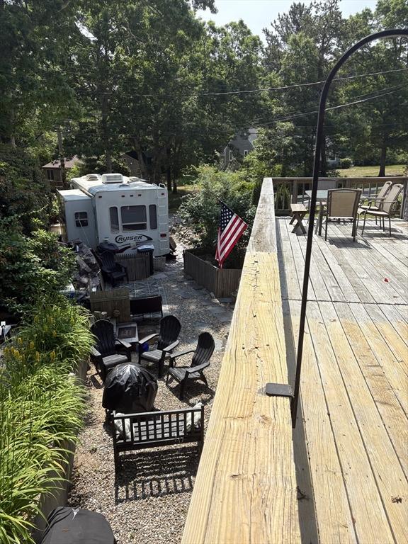 62 Musket, Mashpee, MA 02649 - deck featuring outdoor dining area and view of wooded area