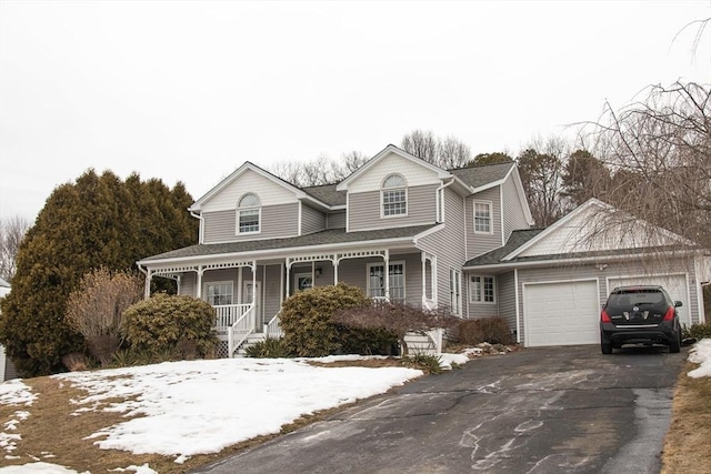 view of front of home featuring an attached garage, aphalt driveway, and a porch