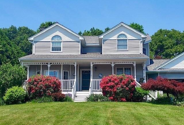 view of front of house with a porch and a front yard