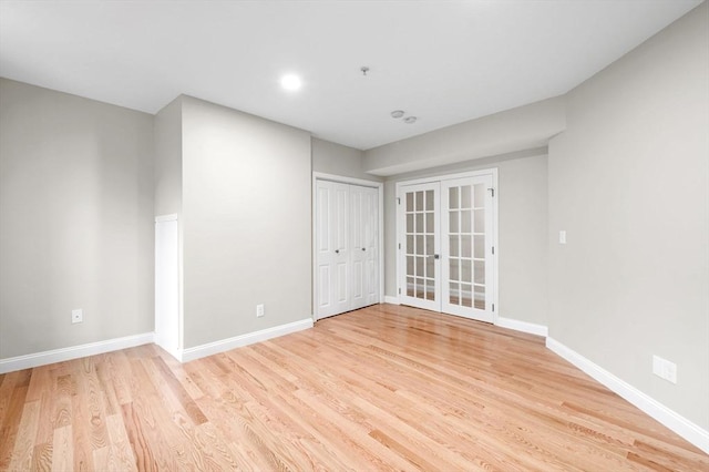 72 River St Unit 5, Haverhill, MA 01832 - unfurnished room with light wood-style floors, baseboards, french doors, and fire sprinkler in ceiling