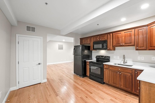 72 River St Unit 5, Haverhill, MA 01832 - kitchen featuring black appliances, a sink, light countertops, light wood-style flooring, and baseboards