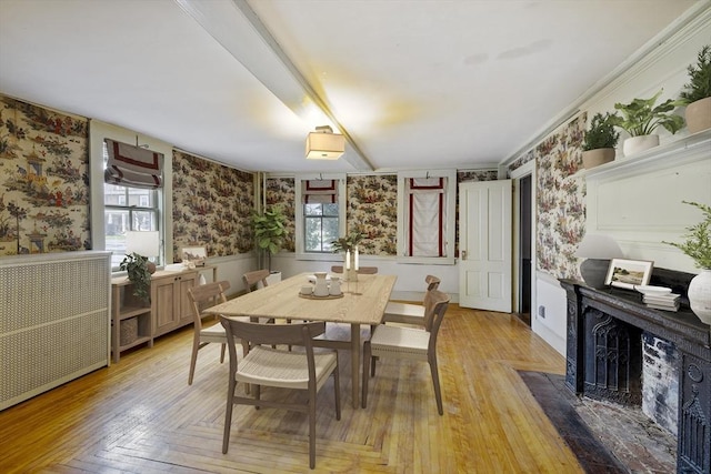 50 Humphrey St, Marblehead, MA 01945 - dining space with wallpapered walls, a fireplace with flush hearth, a wainscoted wall, plenty of natural light, and light wood finished floors