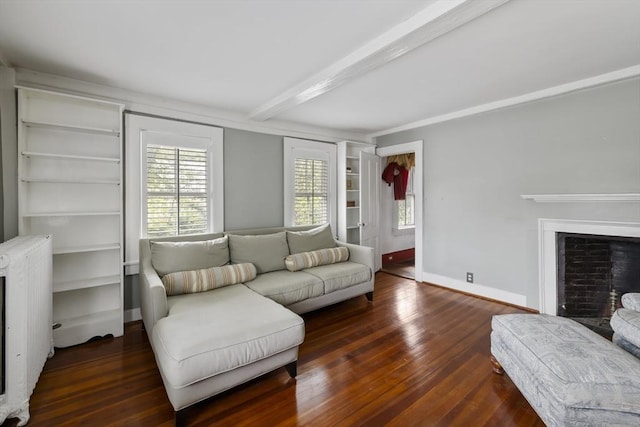 50 Humphrey St, Marblehead, MA 01945 - living area with radiator heating unit, wood finished floors, plenty of natural light, beamed ceiling, and a fireplace with raised hearth
