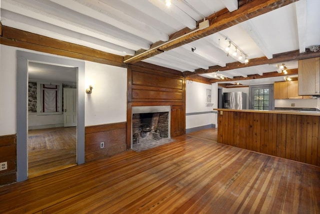 50 Humphrey St, Marblehead, MA 01945 - unfurnished living room featuring hardwood / wood-style floors, a large fireplace, beam ceiling, wood walls, and wainscoting