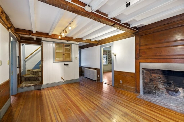 50 Humphrey St, Marblehead, MA 01945 - unfurnished living room with radiator, wooden walls, hardwood / wood-style flooring, beamed ceiling, and stairs