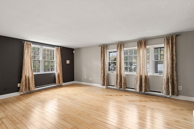 733 W Main Unit G, Barnstable, MA 02630 - spare room featuring baseboard heating, healthy amount of natural light, a textured ceiling, and light wood-style flooring
