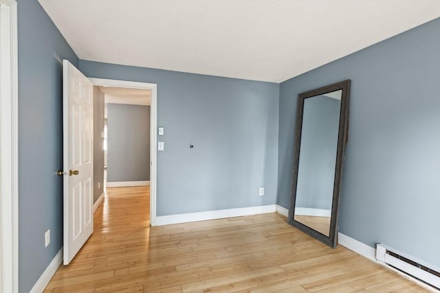 733 W Main Unit G, Barnstable, MA 02630 - unfurnished bedroom featuring a baseboard radiator, baseboards, and light wood-style flooring
