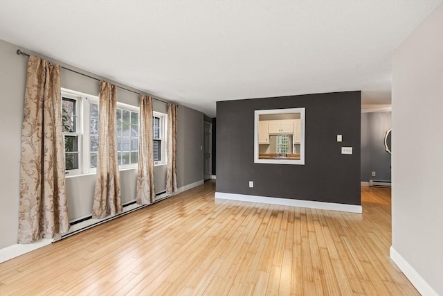 733 W Main Unit G, Barnstable, MA 02630 - unfurnished room featuring a baseboard heating unit, light wood-style flooring, baseboards, and a baseboard radiator