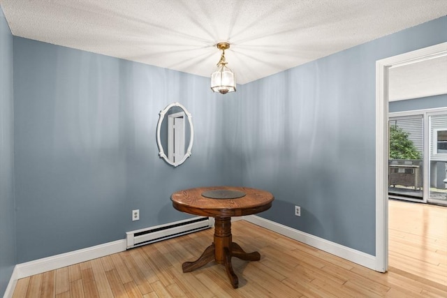 733 W Main Unit G, Barnstable, MA 02630 - unfurnished dining area with a baseboard radiator, baseboards, wood finished floors, and a textured ceiling