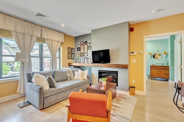 1 Brook Rd Unit 215, Quincy, MA 02169 - living room featuring light wood-type flooring, baseboards, a glass covered fireplace, and recessed lighting