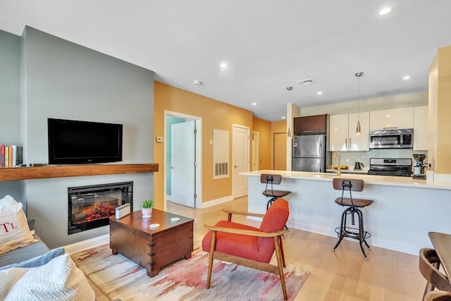 1 Brook Rd Unit 215, Quincy, MA 02169 - living room with light wood finished floors, recessed lighting, a glass covered fireplace, and baseboards