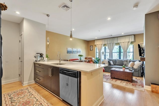 1 Brook Rd Unit 215, Quincy, MA 02169 - kitchen featuring stainless steel dishwasher, light countertops, a sink, light wood-style flooring, and a peninsula
